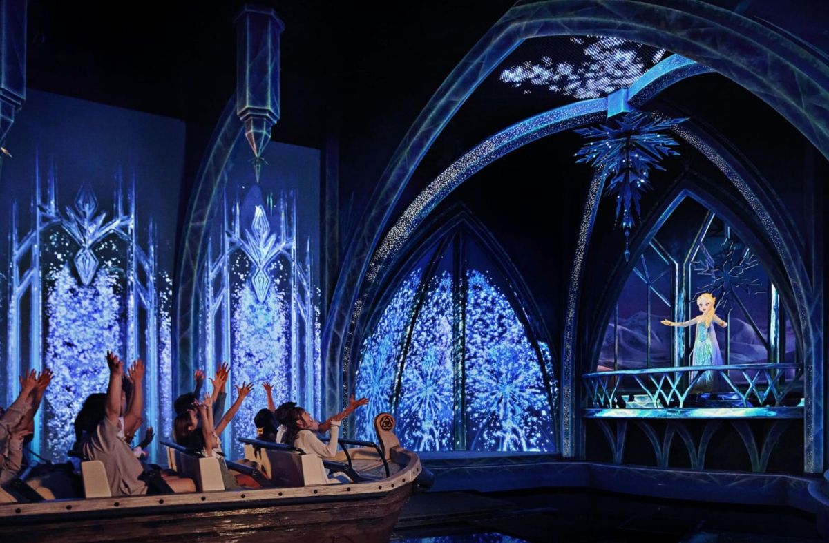 Visiteurs à bord de l’attraction Frozen Ever After, face à Elsa dans le Monde de La Reine des Neiges à Disney Adventure World.