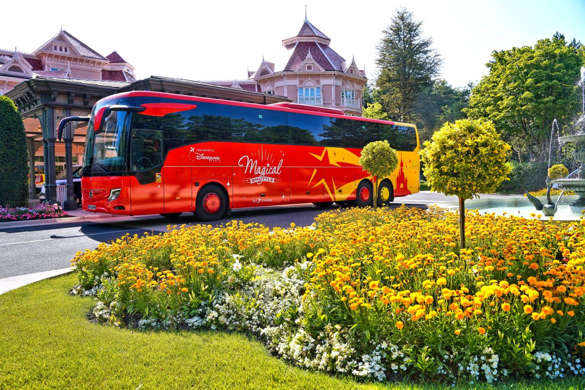 Red Magical Shuttle coach outside a hotel near Disneyland® Paris.